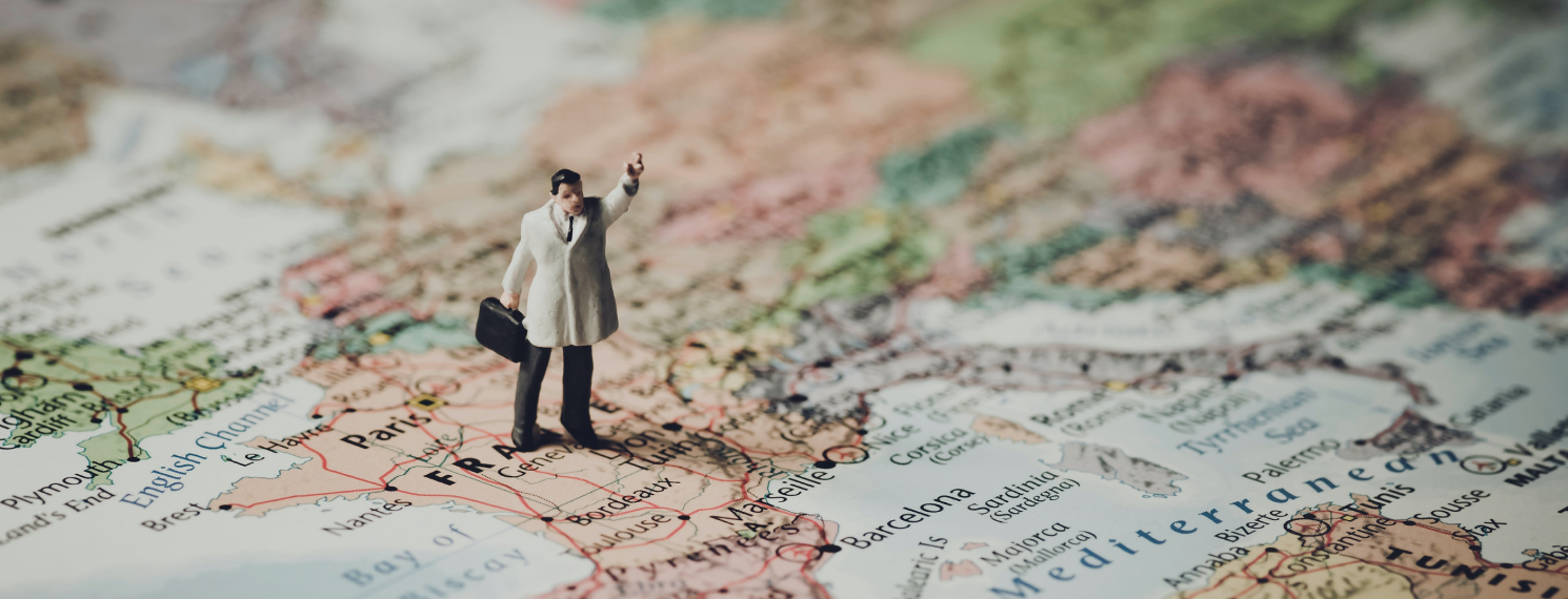 Miniature figure of a man standing on a map of Europe